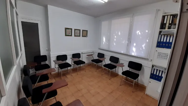 Segunda aula, luminosa, con sillas de pala y estanterías con archivadores